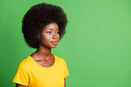 Photo portrait of curly woman looking empty space wearing casual outfit isolated on vivid green color backgroundの写真素材