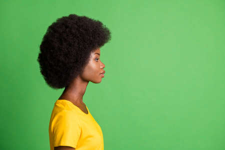 Side profile photo portrait of curly woman looking blank space calm serious isolated on vibrant green color backgroundの写真素材