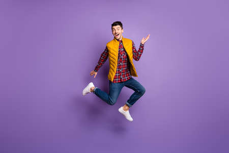 Full size profile photo of optimistic guy run jump wear shirt jeans vest isolated on violet color...