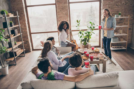 Photo of optimistic brunette blond hairdo guys ladies sit hug play game on party wear casual cloth at homeの写真素材