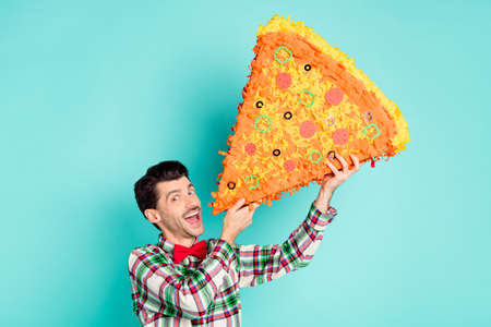 Photo of crazy guy hold big pizza pinata open mouth look camera wear checkered shirt tie isolated blue color backgroundの写真素材