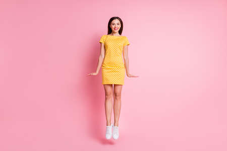 Full size photo of energetic young woman jump up happy smile isolated on pastel pink color backgroundの写真素材