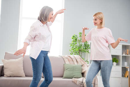 Photo of happy funky cheerful family women dance good mood music lover in living room indoors house homeの写真素材