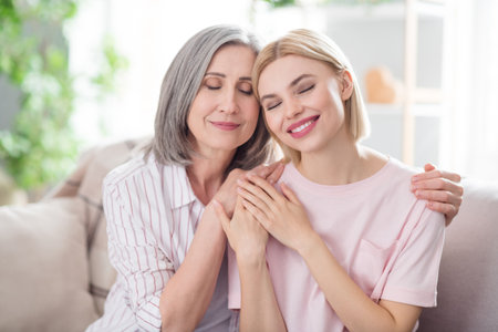 Photo of charming nice positive old woman and young lady hug hold hands enjoy weekend indoors inside...
