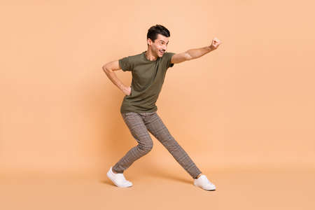 Full size profile photo of hooray brunet guy superhero wear t-shirt trousers sneakers isolated on...