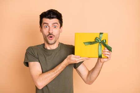 Photo of young shocked amazed surprised man showing demonstrating unexpected present isolated on...