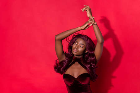 Photo of young attractive black girl gorgeous elegant fancy wear dress isolated over red color backgroundの写真素材