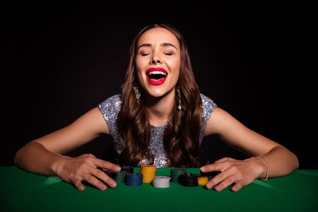 Photo of lady sit poker table open mouth close eyes hands jackpot wear glossy dress isolated black color backgroundの写真素材