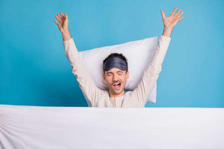 Photo portrait top above high angle view of sleepy man waking up in bed stretching yawning isolated...