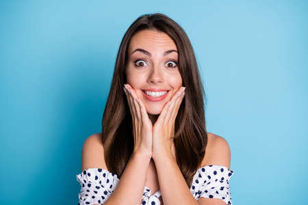 Photo of funky young lady hands amazed face look camera wear dotted blouse isolated blue color...