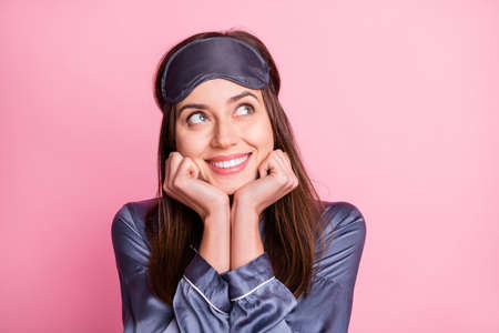 Photo portrait of dreamy woman looking at blank space isolated on pastel pink colored backgroundの写真素材