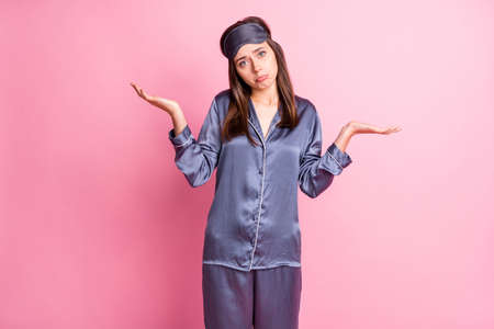 Photo portrait of unhappy woman shrugging pouting isolated on pastel pink colored backgroundの写真素材