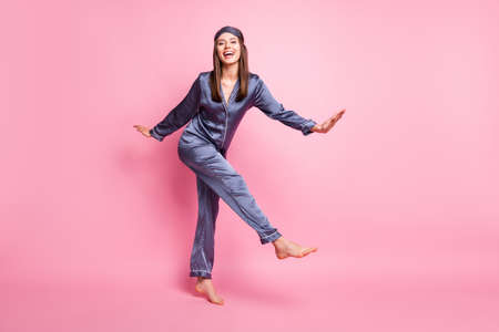Photo portrait full body view of cheerful dancing girl isolated on pastel pink colored backgroundの写真素材