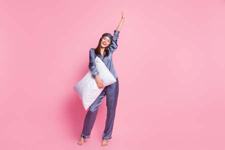 Photo portrait full body view of excited girl raising one hand up isolated on pastel pink colored backgroundの写真素材