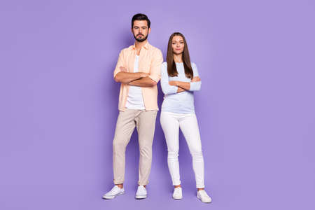 Full length photo of serious man and woman stand together confident folded hands isolated on purple color backgroundの写真素材