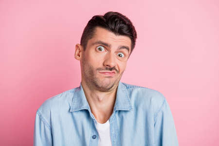 Photo portrait of funny unsure man doubtful grimacing shrugging shoulders not know isolated pastel...