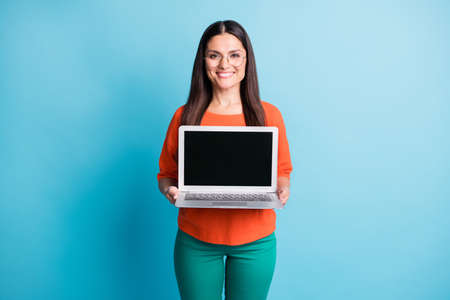 Portrait of friendly person toothy smile hands holding laptop showing display isolated on blue color...