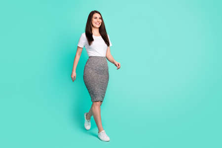 Full body profile side photo of young woman happy positive smile go walk look empty space isolated over turquoise color backgroundの写真素材