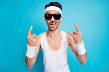 Portrait of carefree excited person two arms fingers show heavy metal symbol isolated on blue color...