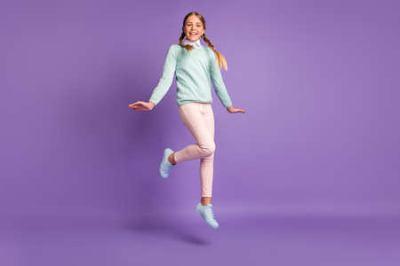 Photo portrait full body view of girl jumping up isolated on vivid purple colored backgroundの写真素材