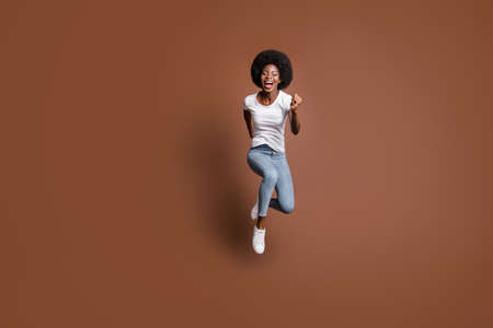Full length body size photo of girl jumping running fast on sale black friday isolated on brown color backgroundの写真素材