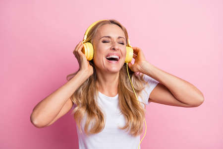 Photo of cool optimistic blond lady closed eyes listen music wear white t-shirt isolated on pastel...