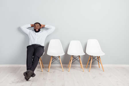 Full length body size photo of smiling man waiting for interviews feeling relaxed sitting on chair in formal wearの写真素材
