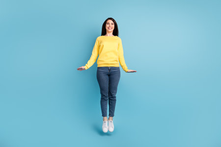 Full size photo of nice optimistic brunette long hairdo lady jump wear shirt jeans sneakers isolated on blue color backgroundの写真素材