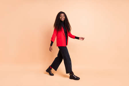 Full size profile side photo of afro american young lady go empty space weekend isolated on beige color backgroundの写真素材