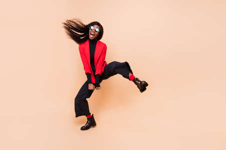 Full length photo of crazy funky afro american lady wear sunglass ride isolated on beige color backgroundの写真素材