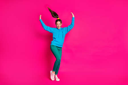 Full length photo of excited charming young lady wear blue sweater dancing hands arms up isolated...