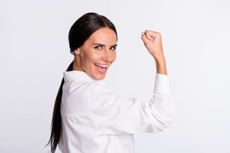 Profile photo of optimistic brunette hairdo lady hand fist wear shirt isolated on grey color backgroundの写真素材