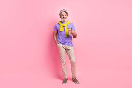 Photo of mature man happy positive smile drink coffee takeout sweater on shoulders isolated over pink color backgroundの写真素材