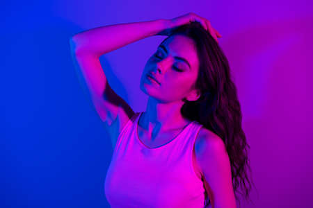 Photo of young stunning gorgeous elegant woman dreaming with closed eyes isolated on glowing blue...