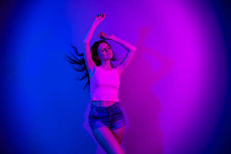 Photo of adorable positive girl closed eyes raise arms enjoy vacation disco isolated on neon gradient backgroundの写真素材