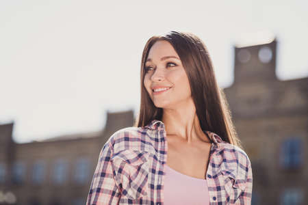 Photo of brunette young woman look wear plaid shirt university graduate charming smile outdoors in outside collegeの写真素材