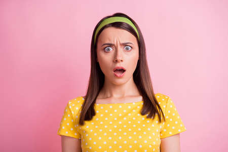 Portrait of stressed pretty brunette girl wear yellow cloth isolated on pastel pink color backgroundの写真素材
