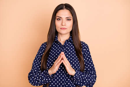 Photo of attractive person arms fingers together thinking look camera isolated on beige color backgroundの写真素材