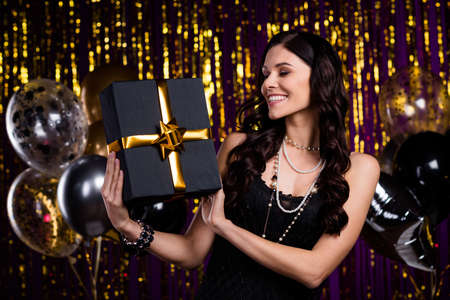 Photo of pretty cheerful lady look arms hold x-mas giftbox have good mood isolated on decorated new...