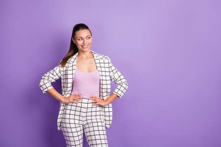 Photo of attractive glamour young woman hold hands waist look empty space smile isolated on purple color backgroundの写真素材