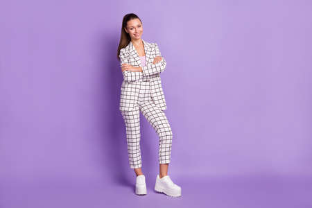 Full length photo of attractive confident young woman hold arms crossed smile isolated on violet color backgroundの写真素材