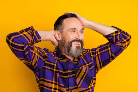 Portrait of attractive cheerful guy wearing checked shirt caressing hair fresh coiffure isolated...