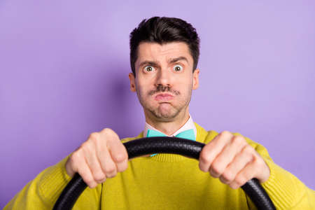 Portrait of brunet stressed guy hold wheel hold air wear yellow sweater isolated on pastel lilac...