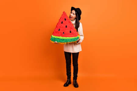 Full size photo of young beautiful funky funny crazy woman ear huge slice of watermelon isolated on orange color backgroundの写真素材