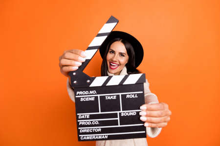 Photo of young charming lovely happy excited smiling woman use clapboard to you isolated on orange color backgroundの写真素材