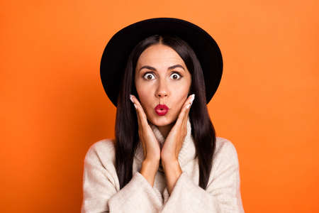 Portrait of attractive amazed woman incredible news reaction pout lips isolated over bright orange color backgroundの写真素材