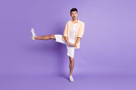 Full size photo of impressed brunet guy dance wear peach shirt shorts sneakers isolated on lilac...