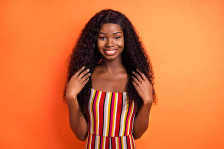 Photo of dark skin happy attractive woman hold hands hair smile good mood isolated on orange color...