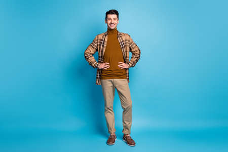 Full size photo of young cheerful handsome smiling positive man wear checkered shirt turtleneck isolated on blue color backgroundの写真素材