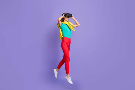 Full length photo of beautiful curly young lady wear sweater shoulders 3d eyewear jumping isolated violet color backgroundの写真素材